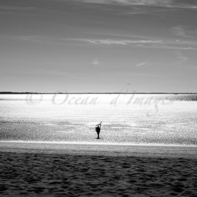 photo en noir et blanc d'un pêcheur en bord de mer plage de chatelaillon