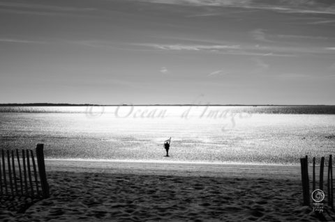 photo en noir et blanc d'un pêcheur en bord de mer plage de chatelaillon