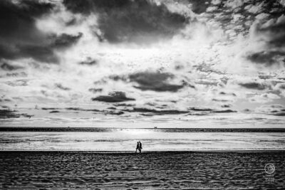 photo en noir et blanc promeneur sur la plage